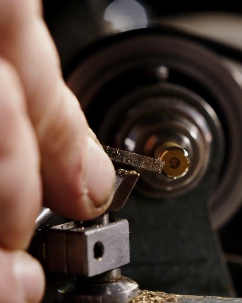 CNC machining center cutting a metal component under coolant